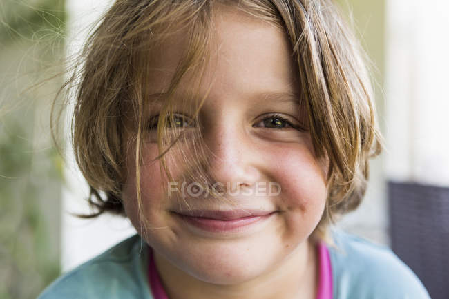 Porträt eines lächelnden kleinen blonden Jungen, der in die Kamera blickt. — Stockfoto