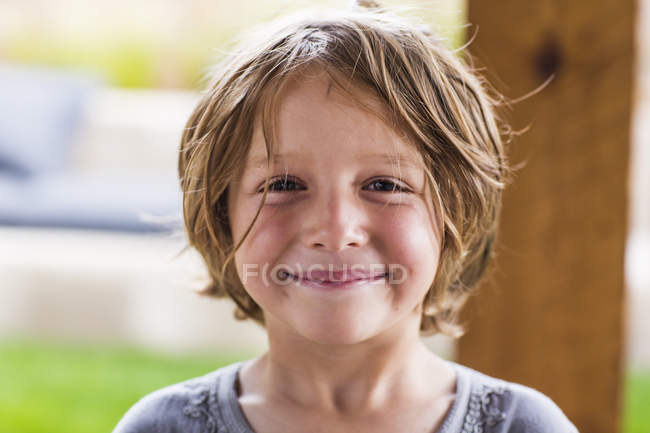 Niño de edad elemental sonriendo en cámara, retrato - foto de stock