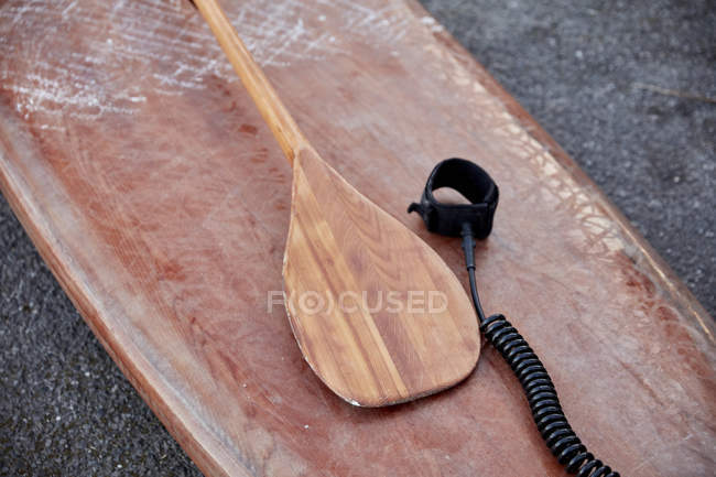 Close-up of wooden paddleboard and paddle on shore — Stock Photo