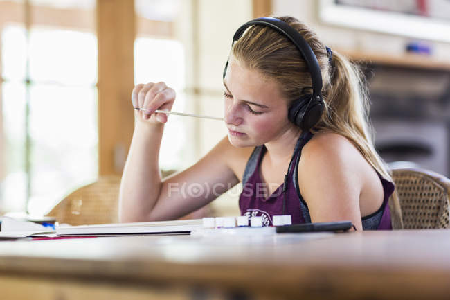 Adolescente à la maison portant des écouteurs comme peinture — Photo de stock