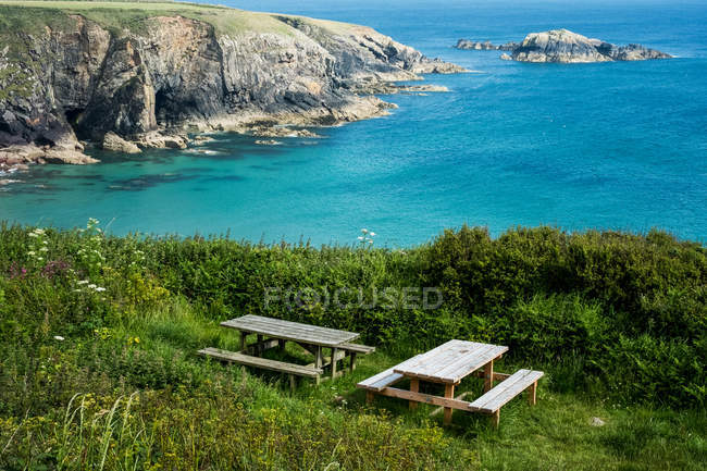 Hölzerne Picknicktische auf Klippen an der Küste von Pembrokeshire, Wales, Großbritannien. — Stockfoto