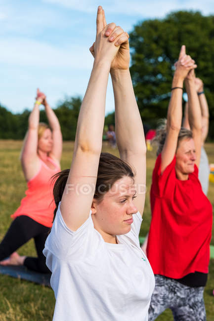 Groupe de femmes prenant part à un cours de yoga en plein air sur une colline . — Photo de stock