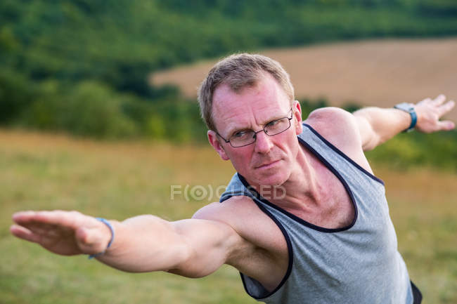 Man taking part in outdoor yoga class on a hillside. — Stock Photo