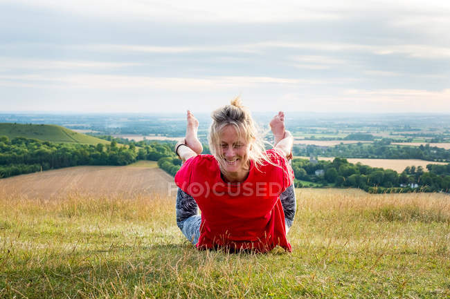 Зріла жінка бере участь у відкритому класі йоги на схилі пагорба . — стокове фото
