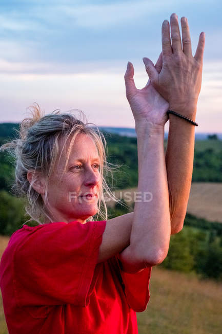 Зріла жінка бере участь у класі йоги на схилі пагорба . — стокове фото