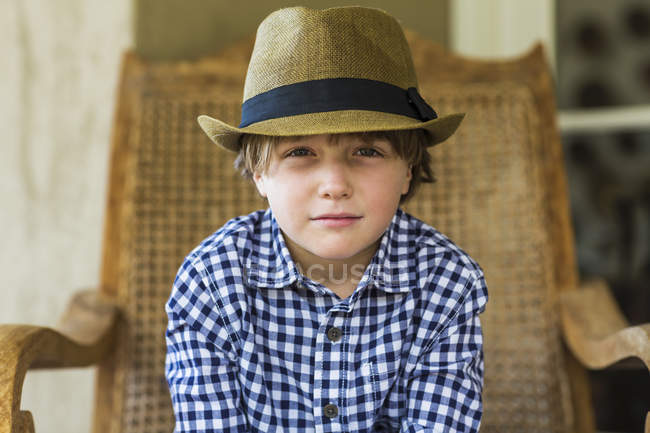 Retrato de menino sentado na cadeira de vime — Fotografia de Stock