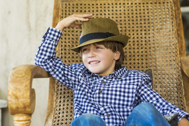 Porträt eines kleinen Jungen im Korbstuhl — Stockfoto