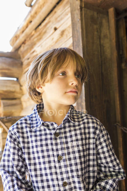 Retrato de menino pré-adolescente olhando para longe no celeiro da fazenda — Fotografia de Stock