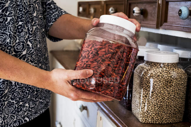Close-up of person holding jar with Goji berries. — Stock Photo