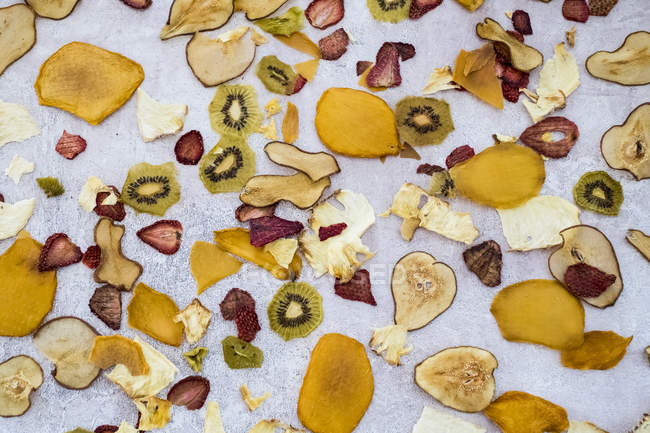 Alto angolo close-up fette di frutta secca tra cui mango, mela, kiwi e fragole . — Foto stock