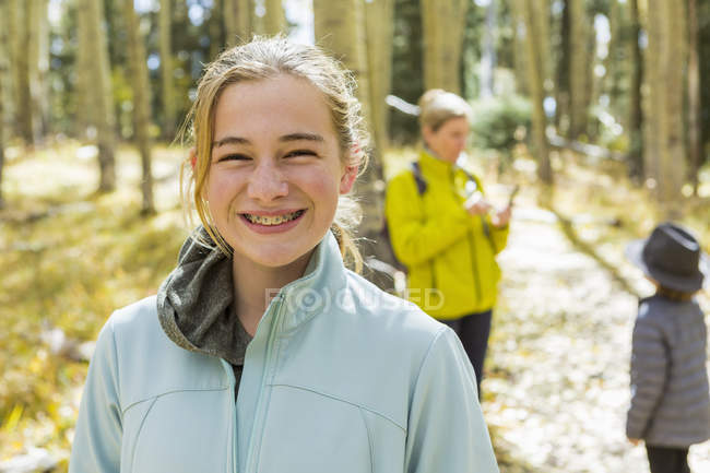 Teenager-Mädchen mit Mutter und Bruder im saisonalen Wald — Stockfoto