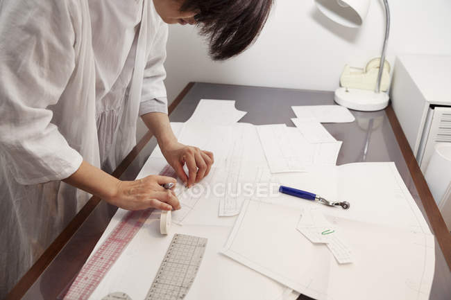Woman working at a desk in a small fashion boutique. — Stock Photo
