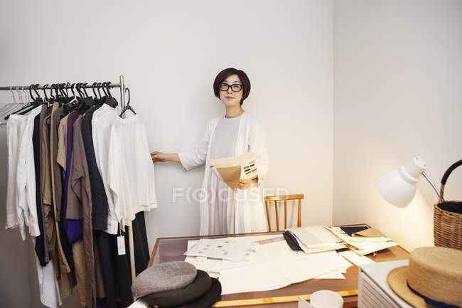 Japanese Woman In Glasses Working At A Desk In A Small