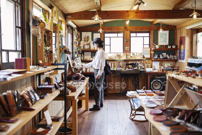 Японська жінка переглядає товари в шкіряному магазині.. — стокове фото