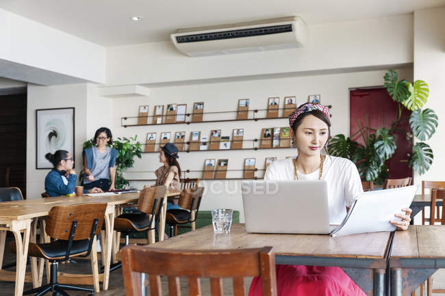 Des hommes d'affaires japonais travaillant sur des ordinateurs portables dans un espace de co-travail . — Photo de stock