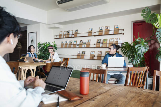 Japanese businesspeople working on laptop computers in a co-working space. — Stock Photo