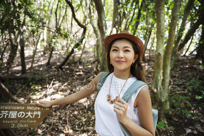 Japanerin mit Hut wandert im Wald. — Stockfoto