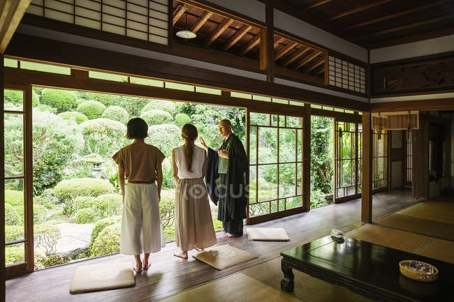Buddhist priest and women standing in Buddhist temple. — Stock Photo
