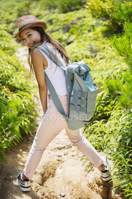 Japanese woman wearing hat and carrying backpack on a hike. — Stock Photo