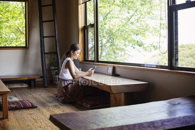 Femme japonaise assise à une table dans un restaurant japonais . — Photo de stock