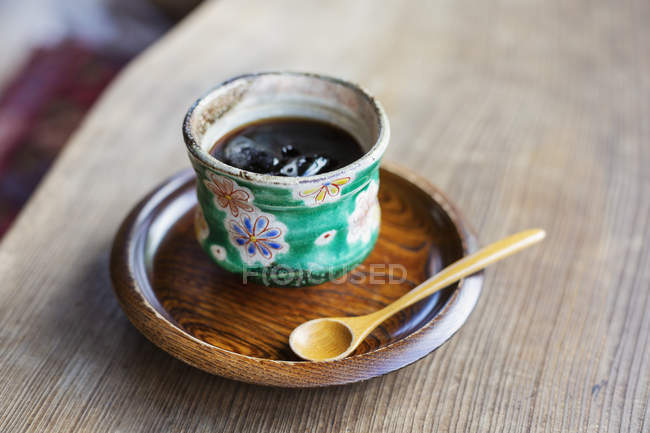 Высокоугольный крупный план японской приправы в зеленой чаше на деревянной тарелке
. — стоковое фото