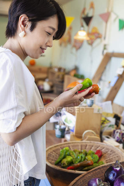 Japanerin kauft frisches Gemüse im Hofladen ein. — Stockfoto