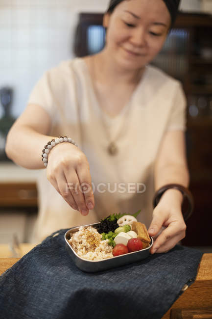 Mulher japonesa preparando legumes frescos em um café vegetariano . — Fotografia de Stock