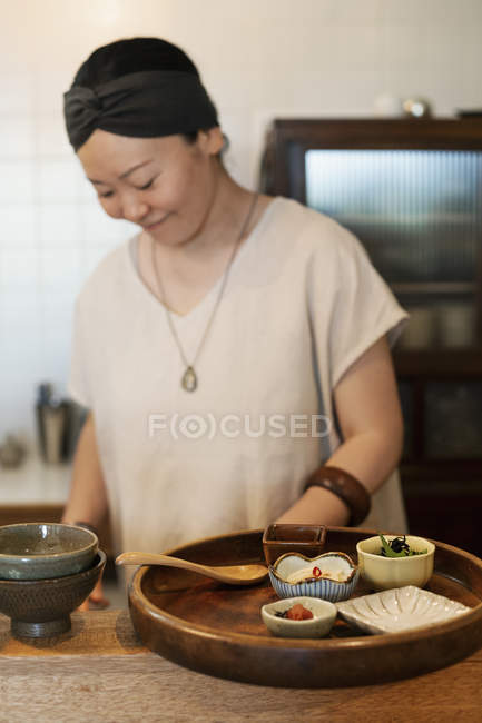 Donna giapponese che prepara verdure fresche in un caffè vegetariano . — Foto stock