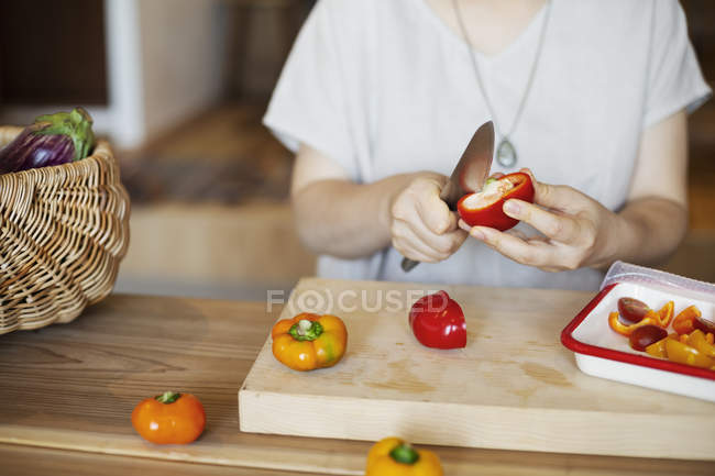 Midsection of woman preparing fresh vegetables in a vegetarian cafe. — Stock Photo