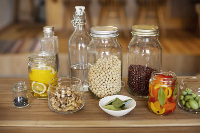 Close-up de uma seleção de condimentos e leguminosas secas em frascos de vidro . — Fotografia de Stock
