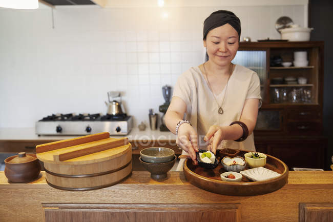 Japanerin bereitet Essen in vegetarischem Café zu. — Stockfoto