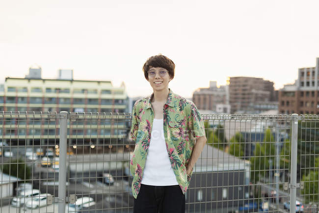 Jovem japonês em pé no telhado em ambiente urbano, olhando para a câmera . — Fotografia de Stock