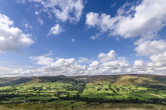 Landscape with fields and distant mountains under a cloudy sky, Peak District National Park. — Stock Photo
