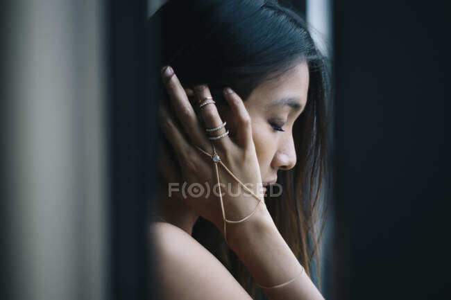 Retrato de la mujer joven cerca de una ventana en Singapur. - foto de stock