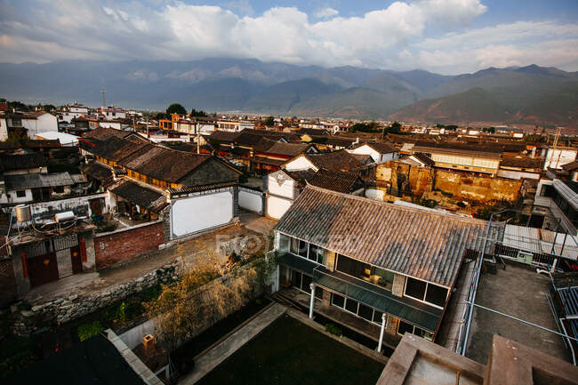 Vue à angle élevé sur les toits des maisons asiatiques traditionnelles, montagnes au loin . — Photo de stock