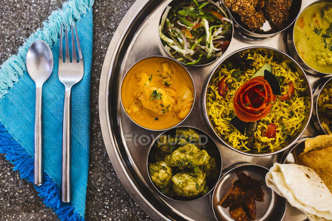 High angle close-up of traditional Indian lunch with rice, various curries, pickles and vegetables. — Stock Photo