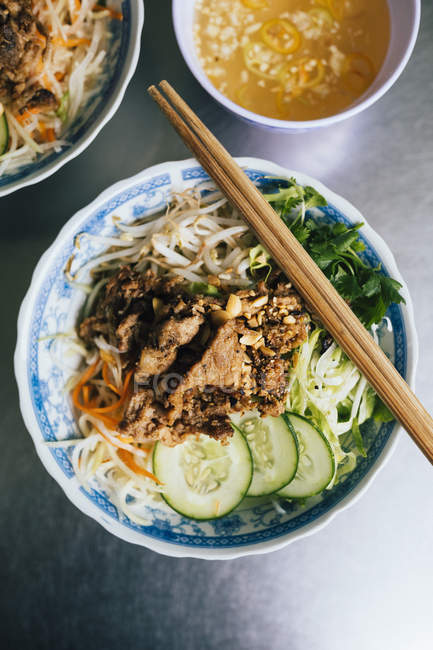 High angle close-up of Bun thit nuong rice noodles with grilled pork and fresh herbs. — Stock Photo