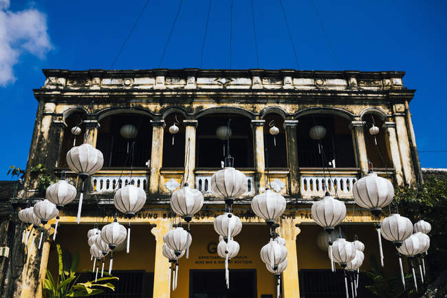 Lanterne bianche tradizionali appese di fronte all'edificio storico, Hoi An, Vietnam . — Foto stock