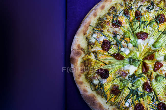 High angle close-up of vegetarian pizza with goat cheese and zucchini flowers. — Stock Photo