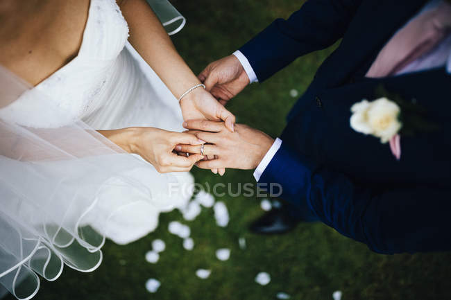 Vista de alto ângulo do marido e da esposa trocando votos e anéis durante a cerimônia de casamento . — Fotografia de Stock