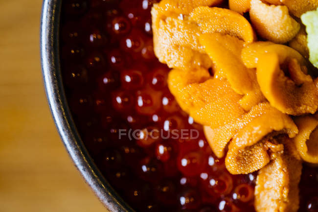 High angle close-up of dish of sea urchin with salmon roe. — Stock Photo