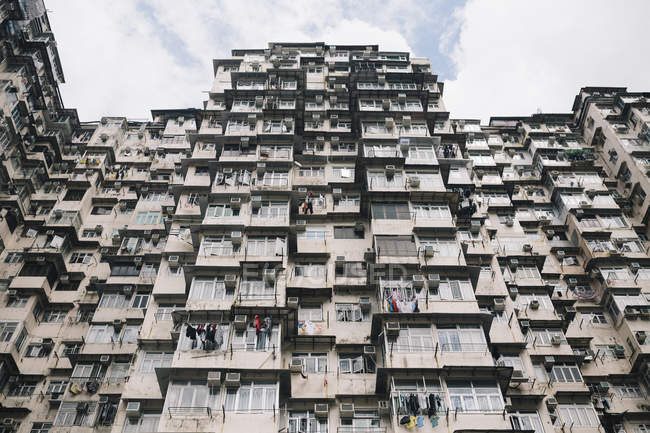 Низький кут Вигляд фасаду висотного житлового комплексу з вікнами й балконами, Гонконг, Китай — стокове фото