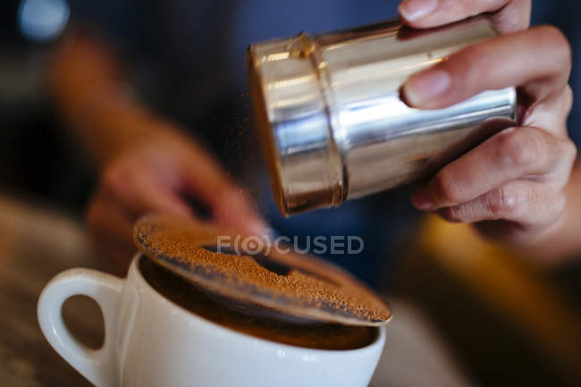 Close-up of barista putting finishing touch on mocha drink. — Stock Photo