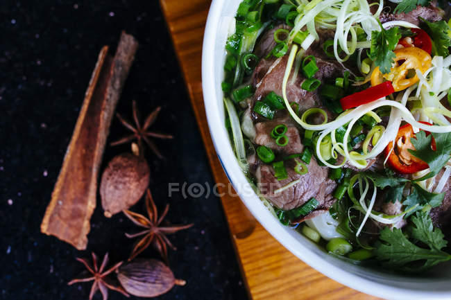 High angle close-up of a bowl of beef pho bo soup. — Stock Photo