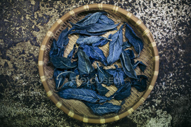 High angle close-up of basket with indigo leaves used to dye cotton. — Stock Photo
