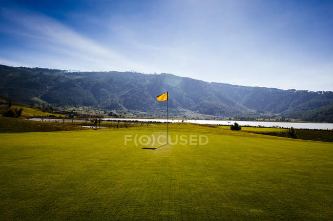 Flag on golf course with sea and mountains in distance, Dalat, Vietnam — Stock Photo