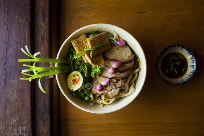 Primer plano de alto ángulo de tazón de fideos Cao lau, plato de especialidad local con fideos hechos en Hoi An, Vietnam . - foto de stock