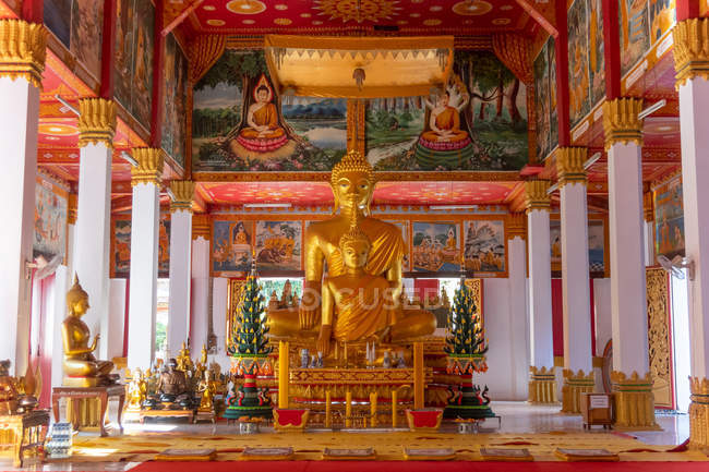 Wat Si Saket large golden Buddha statue and altar with offerings and wall murals, Vientiane, Laos — Stock Photo