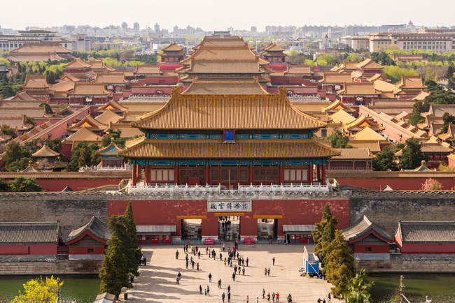 Elevated view over people walking through gate of Forbidden City in cityscape of Beijing, China — Stock Photo