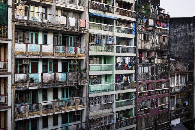 Fachada de filas de casas de apartamentos en ruinas con lavado colgando en balcones . - foto de stock